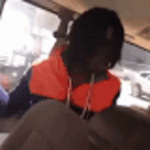A Man Is Sitting In The Back Seat Of A Car . GIF