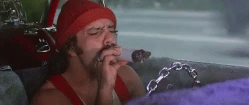 A Man Is Sitting In The Back Seat Of A Car Smoking A Cigarette And Drinking A Beer . GIF