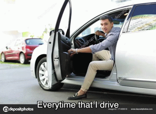 A Man Is Sitting In The Driver 'S Seat Of A Silver Car . GIF