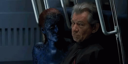 A Man Is Sitting Next To A Blue Monster With A Smile On His Face GIF