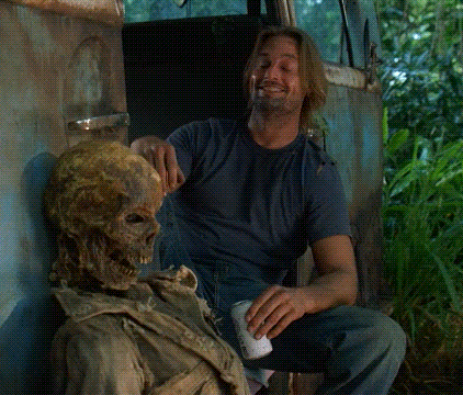 A Man Is Sitting Next To A Skeleton And Holding A Can Of Beer GIF