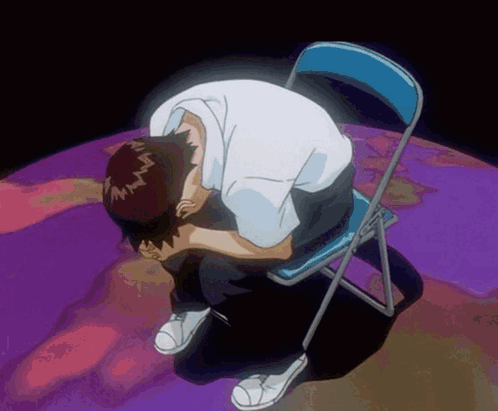 A Man Is Sitting On A Blue Chair With His Head In His Hands GIF