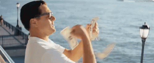 A Man Is Sitting On A Boat Holding A Bunch Of Money In His Hand . GIF