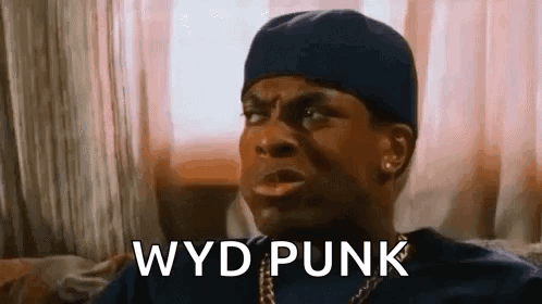 A Man Is Sitting On A Couch And Making A Funny Face While Wearing A Hat . GIF