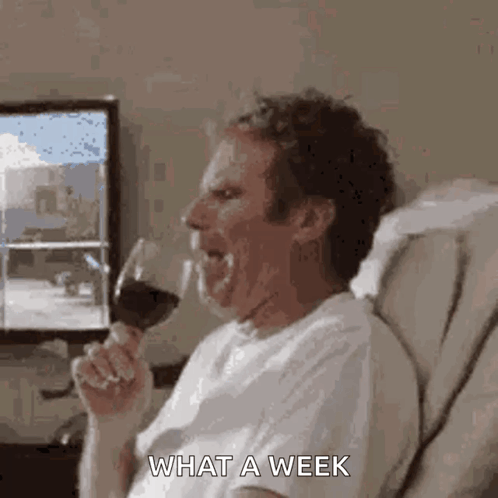A Man Is Sitting On A Couch Drinking A Glass Of Wine And Making A Funny Face . GIF