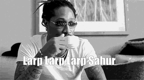 A Man Is Sitting On A Couch Drinking From A Cup . GIF