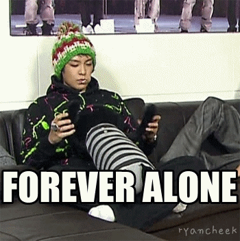 A Man Is Sitting On A Couch Holding A Cell Phone With The Words Forever Alone Above Him . GIF