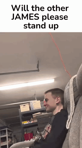 A Man Is Sitting On A Couch In A Garage With A Caption That Says Will The Other James Please Stand Up GIF