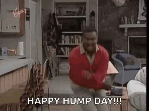 A Man Is Sitting On A Couch In A Living Room And Dancing . GIF
