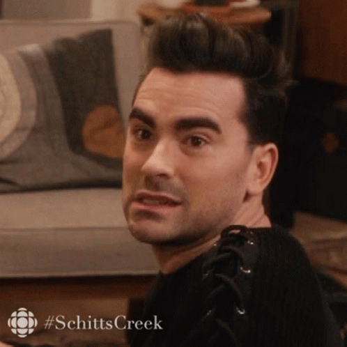 A Man Is Sitting On A Couch In A Living Room And Making A Face . GIF