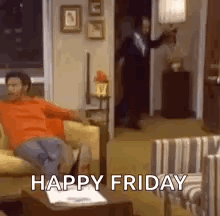A Man Is Sitting On A Couch In A Living Room With The Words `` Happy Friday '' Written On It . GIF