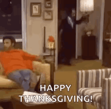 A Man Is Sitting On A Couch In A Living Room With The Words `` Happy Thanksgiving ! '' GIF