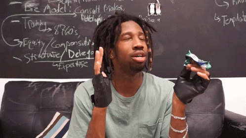 A Man Is Sitting On A Couch In Front Of A Blackboard That Says Biz Model On It GIF