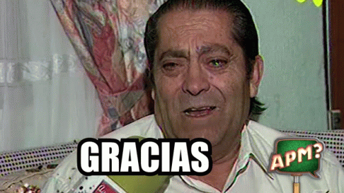 A Man Is Sitting On A Couch With A Gracias Sign Above Him GIF