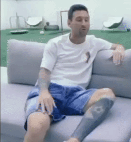 A Man Is Sitting On A Couch With His Legs Crossed GIF