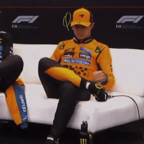 A Man Is Sitting On A Couch With His Legs Crossed And His Shirt Says Dell Technologies On It GIF