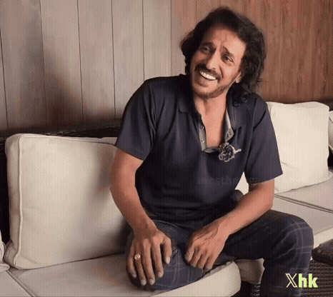 A Man Is Sitting On A Couch With The Letters Xhk On The Bottom GIF