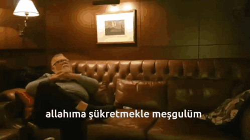 A Man Is Sitting On A Couch With The Words Allahima Şükretmekle Mesgulum Above Him GIF