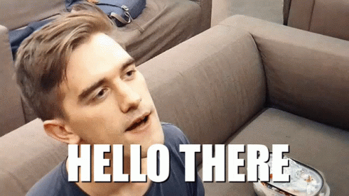 A Man Is Sitting On A Couch With The Words Hello There Above Him GIF