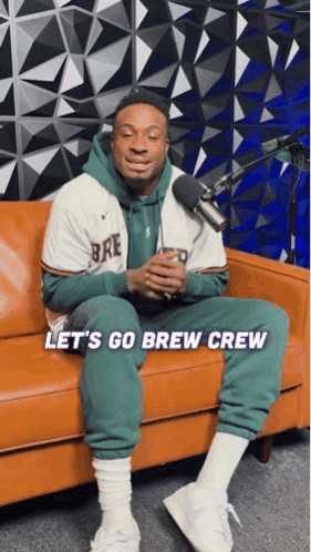 A Man Is Sitting On A Couch With The Words Let 'S Go Brew Crew On The Bottom GIF