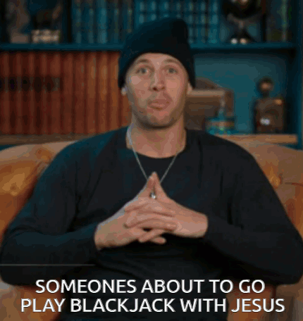 a man is sitting on a couch with the words someones about to go play blackjack with jesus