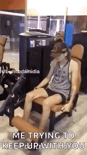 A Man Is Sitting On A Leg Extension Machine In A Gym And Says `` Me Trying To Keep Up With You '' . GIF