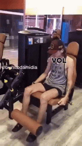 A Man Is Sitting On A Machine In A Gym With A Caption That Says Vol GIF