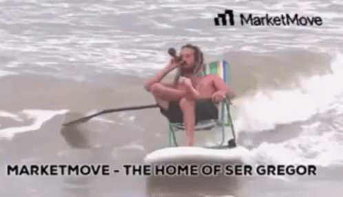 A Man Is Sitting On A Surfboard In The Ocean While Drinking From A Bottle . GIF