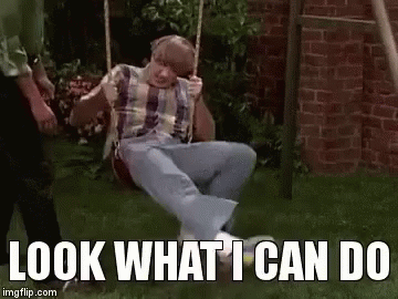 A Man Is Sitting On A Swing With The Words `` Look What I Can Do '' Written Below Him . GIF