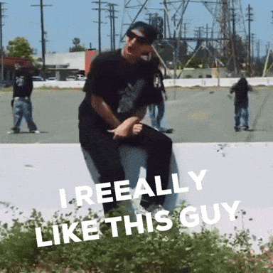 A Man Is Sitting On A Wall With The Words " I Reeally Like This Guy " On The Bottom GIF