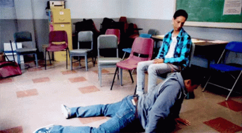 A Man Is Sitting On Another Man 'S Back In A Room With Chairs GIF