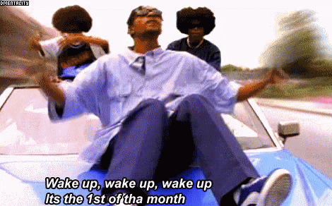 A Man Is Sitting On The Back Of A Car With The Words Wake Up Wake Up Wake Up Its The 1St Of The Month GIF