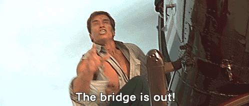 A Man Is Sitting On The Side Of A Building With The Words `` The Bridge Is Out '' Written On His Face . GIF