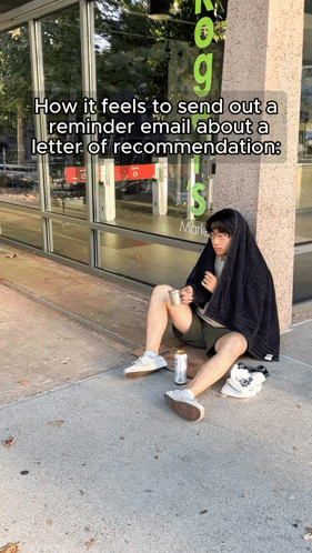 A Man Is Sitting On The Sidewalk In Front Of A Store That Says Marks GIF