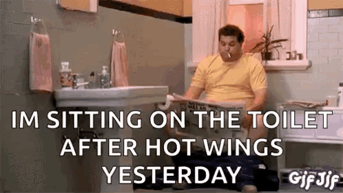 A Man Is Sitting On The Toilet Reading A Newspaper . GIF