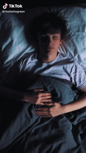 A Man Is Sleeping In A Bed With A Tiktok Watermark GIF