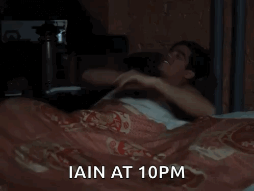 A Man Is Sleeping In A Bed With The Words Iain At 10Pm GIF