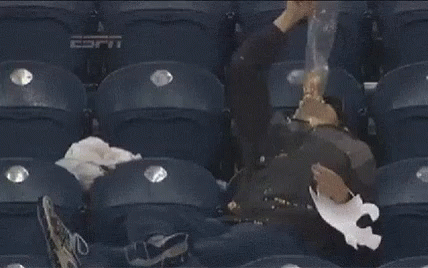 a man is sleeping in a stadium with espn written on the seat