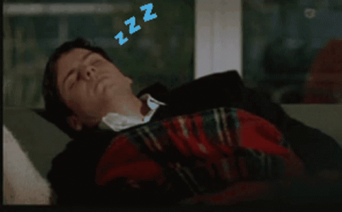 A Man Is Sleeping On A Couch With Zzz Above His Head GIF