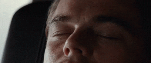 A Man Is Sleeping With His Eyes Closed In A Car Seat GIF
