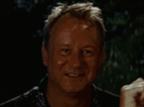 A Man Is Smiling And Holding A Piece Of Paper GIF