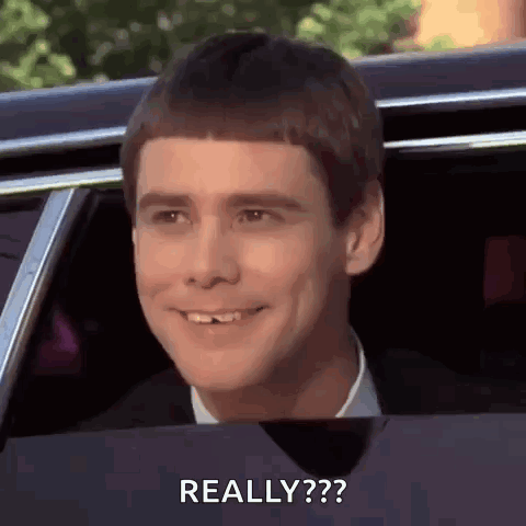 A Man Is Smiling And Looking Out Of A Car Window With The Words `` Really '' Written On The Bottom . GIF