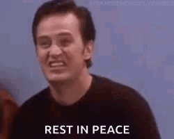 A Man Is Smiling And Saying `` Rest In Peace '' While Standing In Front Of A Group Of People . GIF