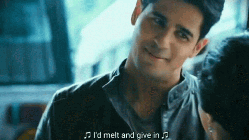 A Man Is Smiling And Talking To A Woman While Holding A Microphone . GIF