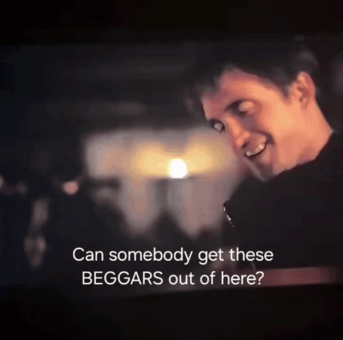 A Man Is Smiling In A Dark Room With The Words " Can Somebody Get These Beggars Out Of Here " GIF