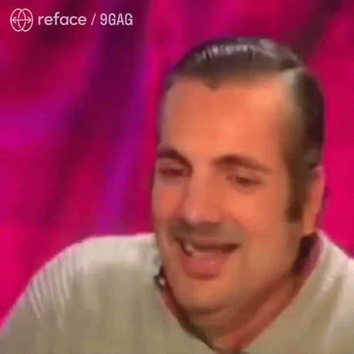A Man Is Smiling In Front Of A Pink Background That Says Reface / 9Gag On It GIF