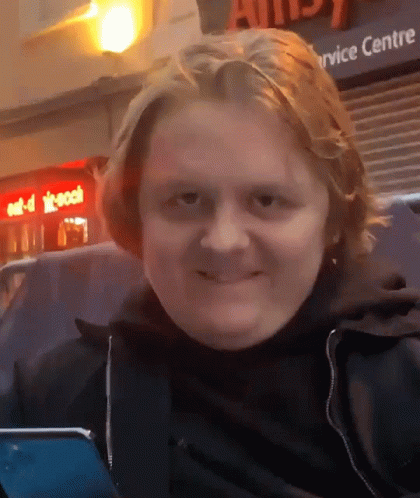 A Man Is Smiling In Front Of A Service Centre Sign GIF