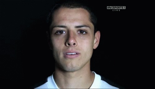 a man is smiling in front of a sky sports live sign