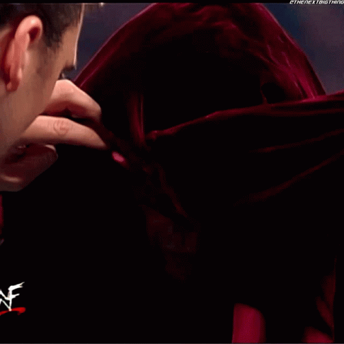 A Man Is Smiling In Front Of A Wrestler Logo GIF
