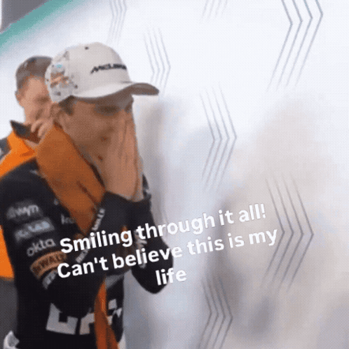 A Man Is Smiling Through It All While Covering His Face With His Hands . GIF